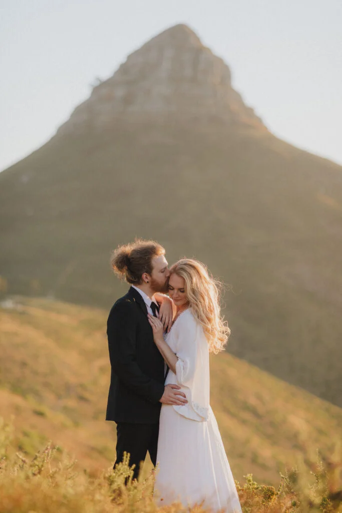 Wedding Couple embracing beneath Lions Head Mountain in Cape Town