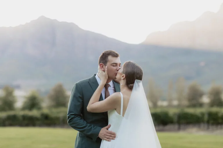 Wedding couple kissing with sunlit Tulbagh mountain behind them