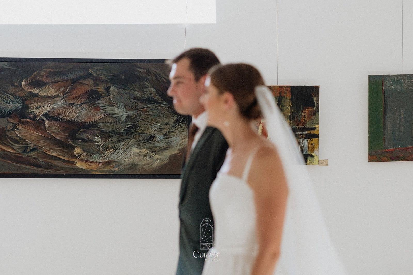 Wedding couple walk through the art gallery at saronsberg wedding venue