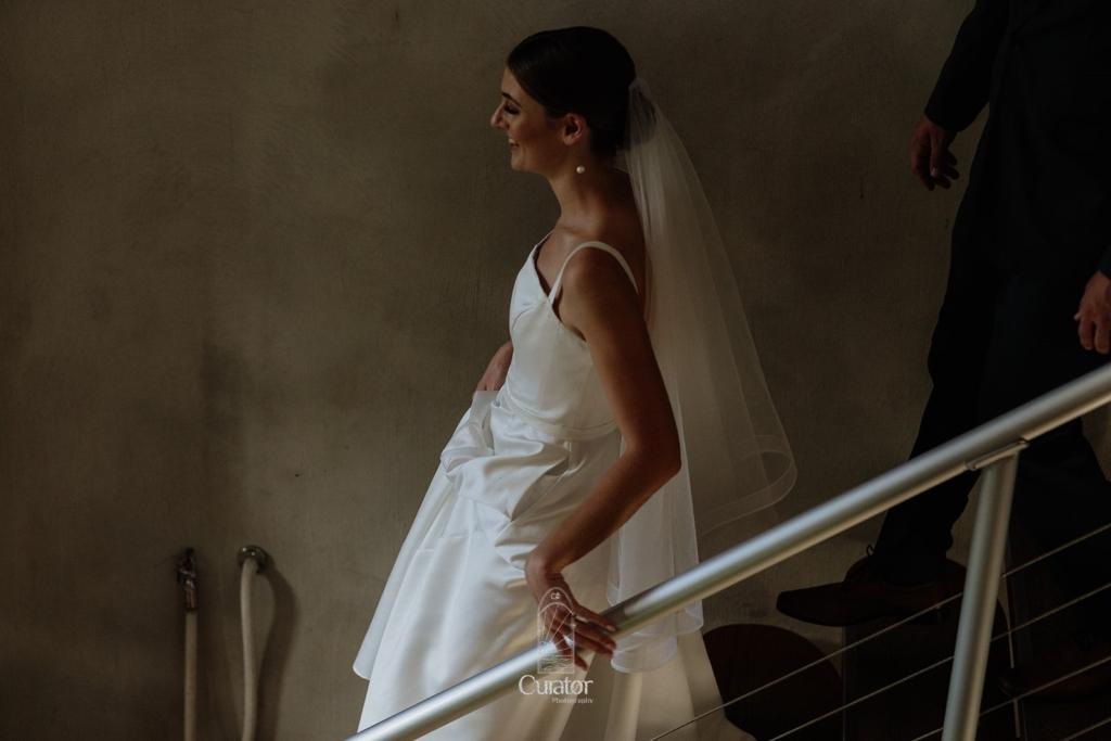Side profile of a bride walking down stairs 
