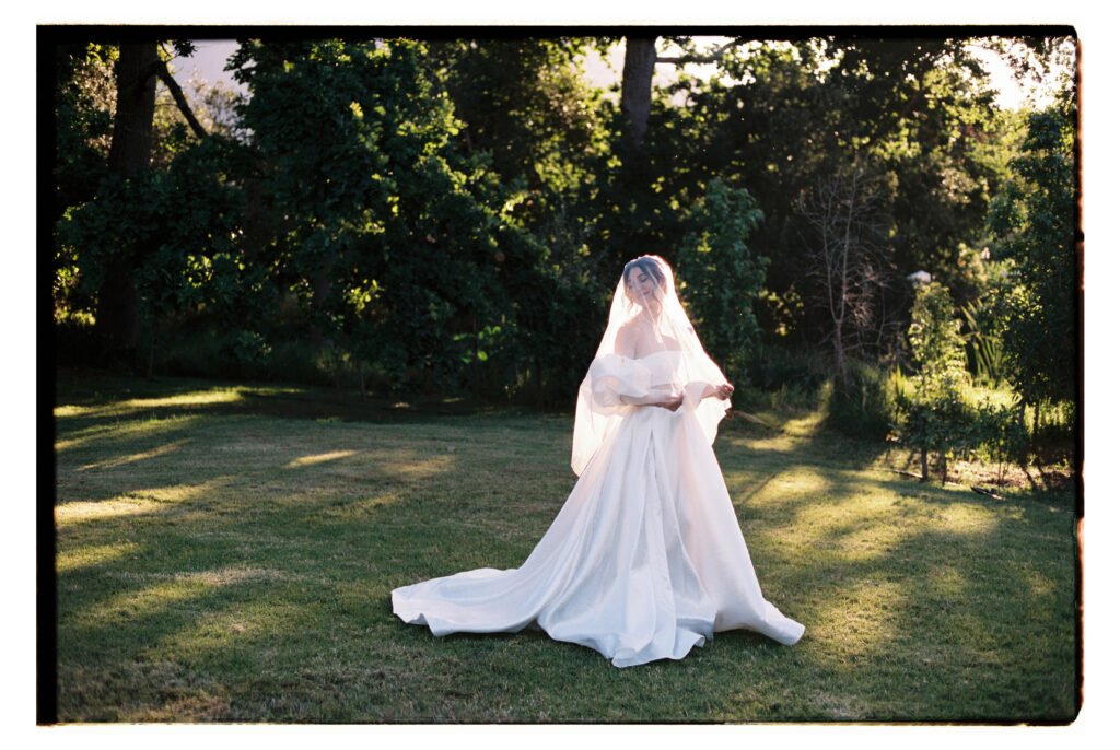 Bride photographed on film while she stands in the sun