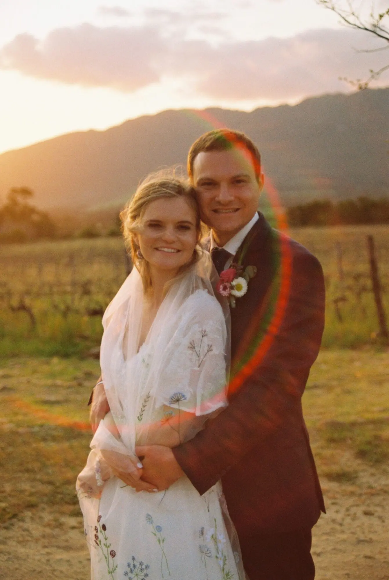 Wedding couple on 35mm film with a rainbow lens flare