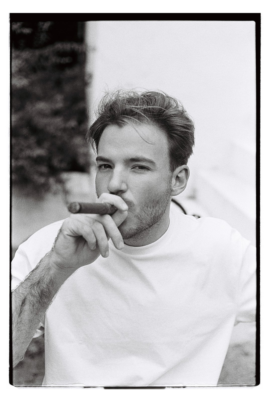 Groom portrait on film while he's smoking a cigar.