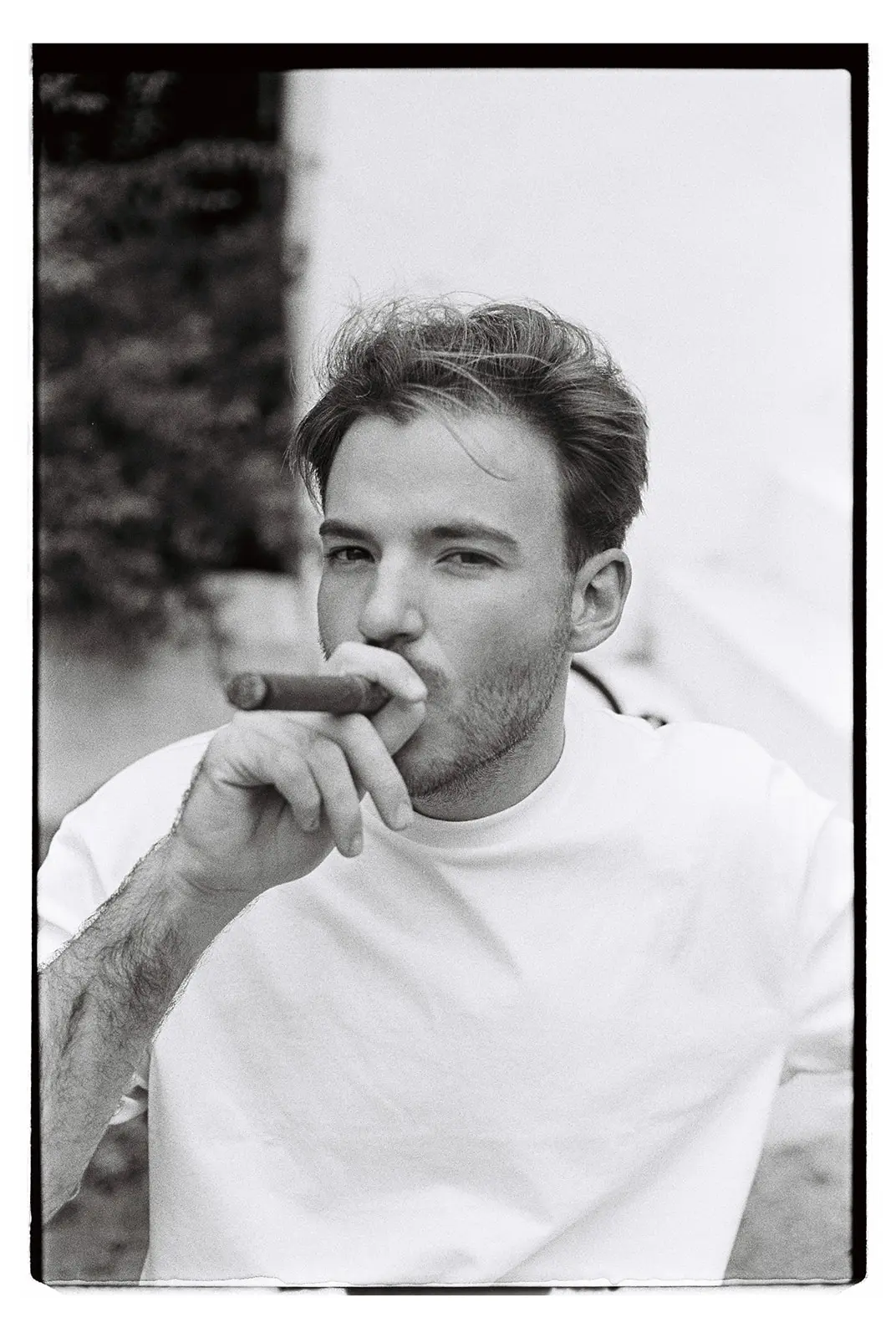 Groom portrait on film while he's smoking a cigar.
