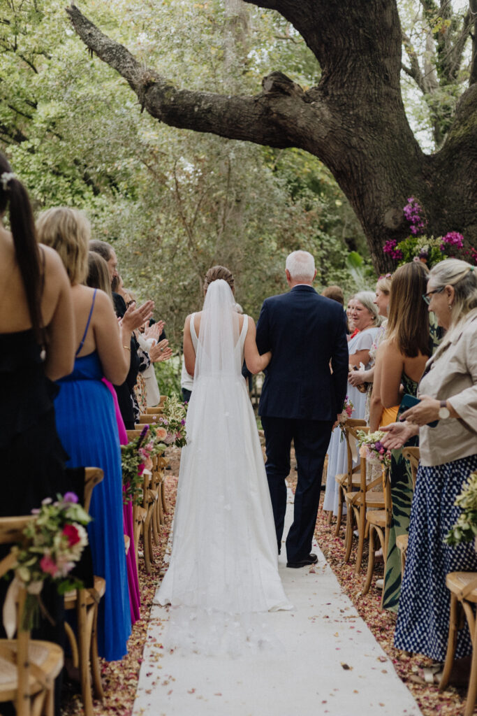 Bride and dad walk down wedding aisle at Montpellier forest venue