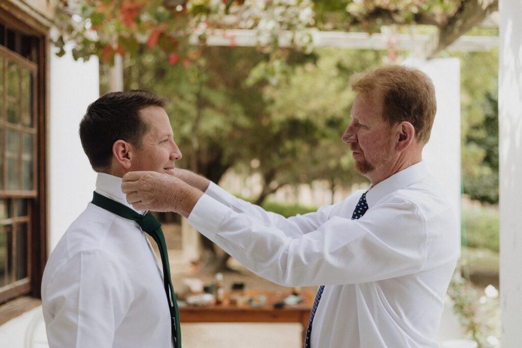 Dad ties sons tie at wedding