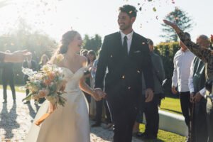 Wedding couple laughing while getting confetti thrown at them