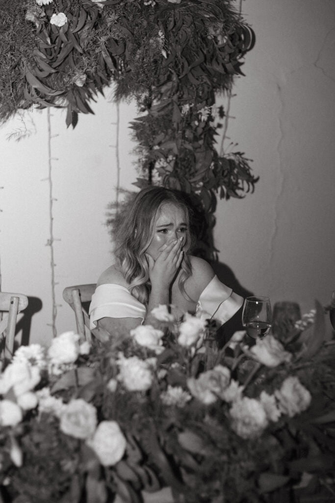 Black and white of an emotional bride at her wedding.