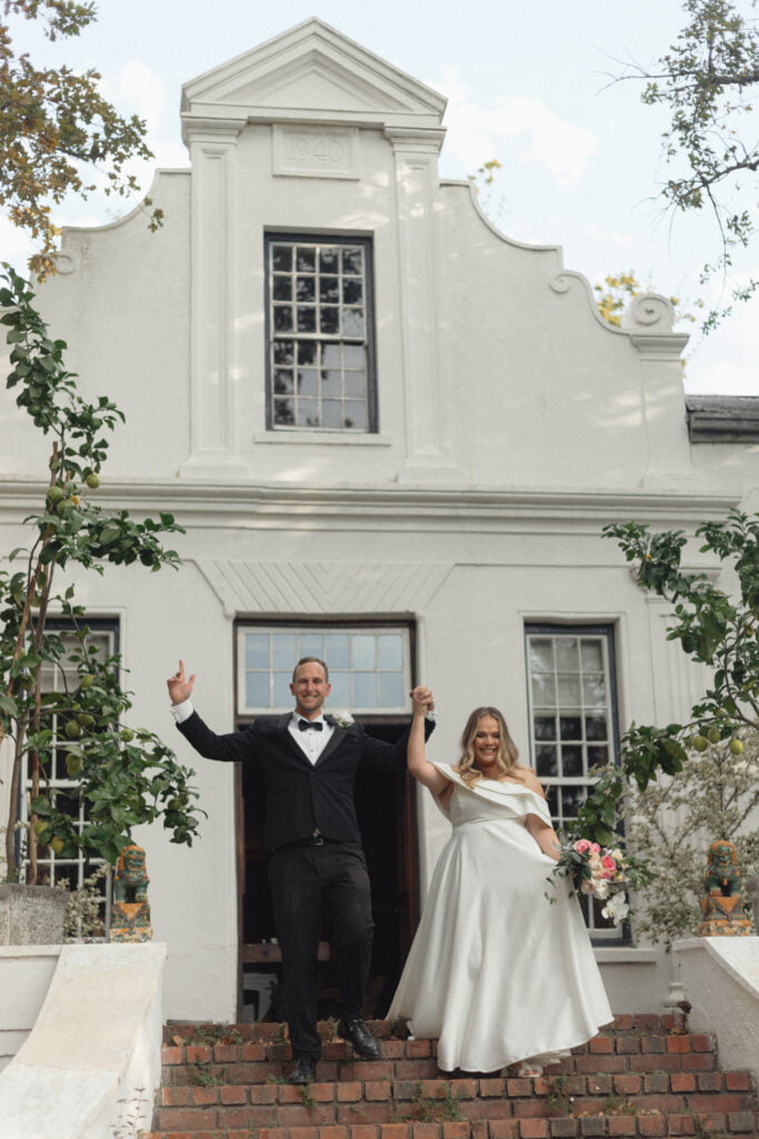 Bride and groom triumphantly walk down the steps outside Natte Vallejo's main house.