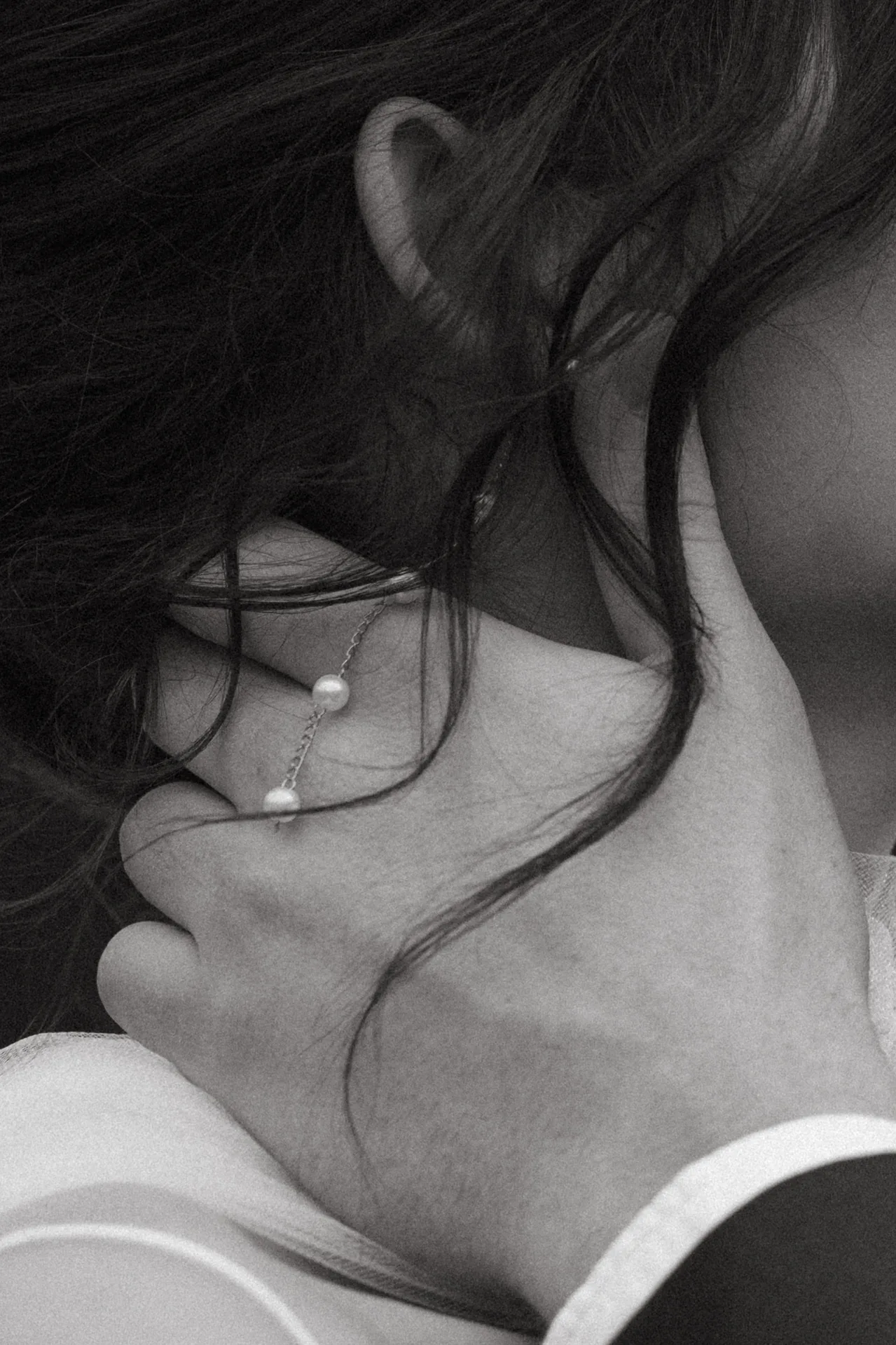 Close up side profile of a man's hand lovingly holding a women's head underneath her earring.