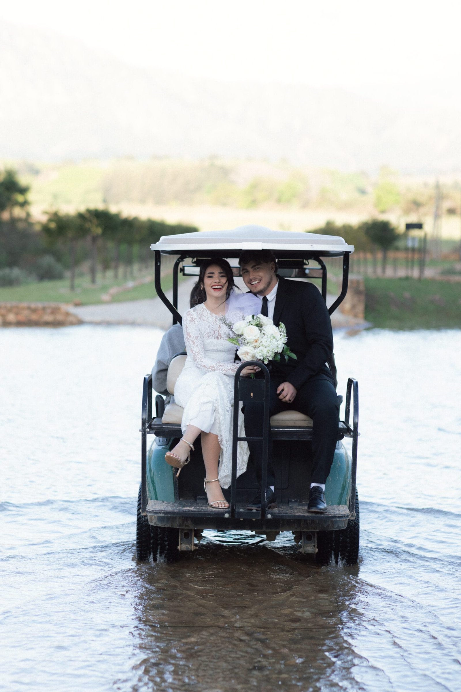 Wedding couple crossing the lake in a golf car at la Roche