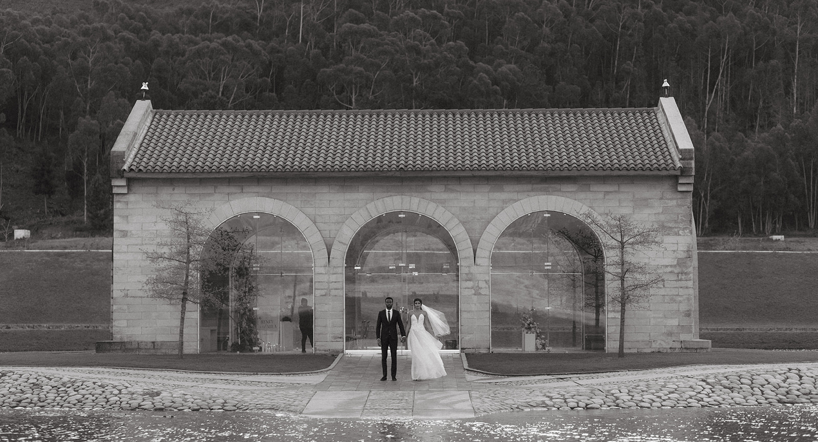 Black and white wedding photo of a wedding couple standing outside the sanctuary at La Roche