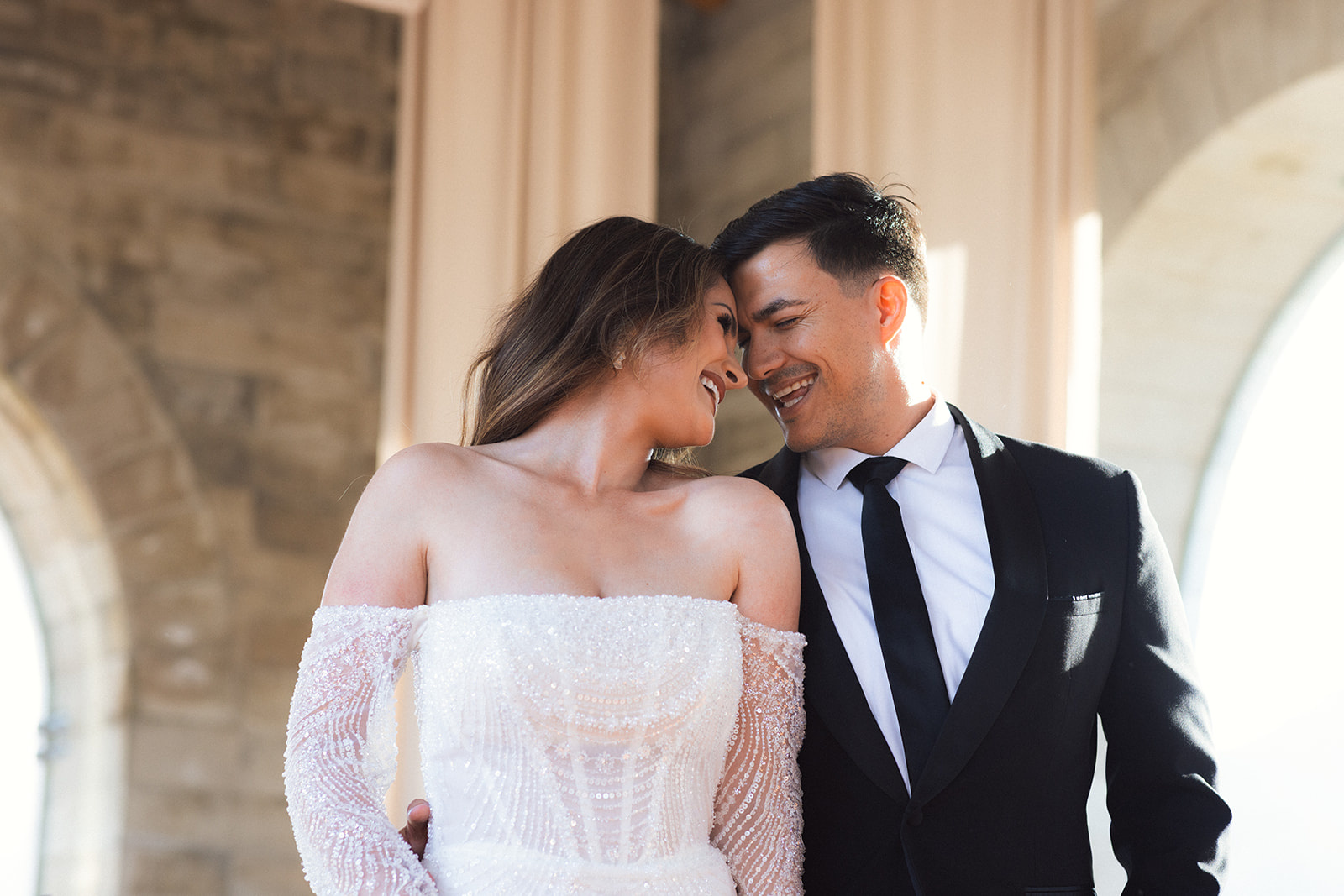 A wedding couple putting their heads together and laughing inside La Roche's stone sanctuary