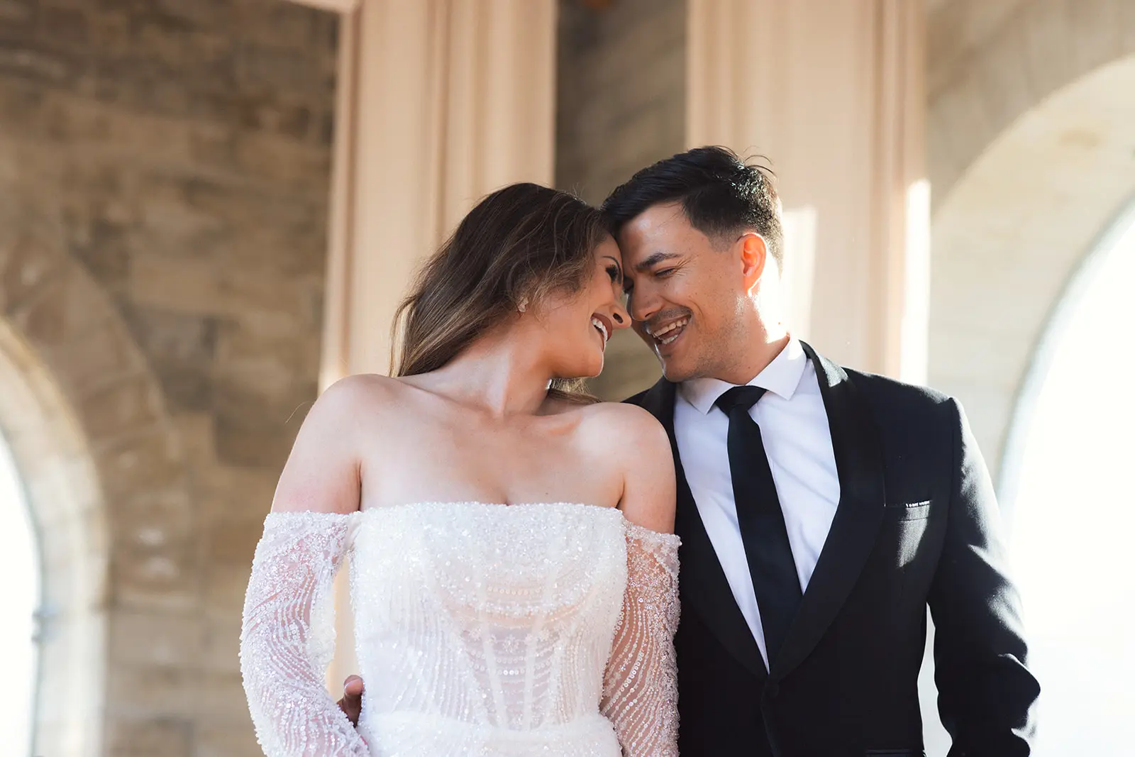 A wedding couple putting their heads together and laughing inside La Roche's stone sanctuary