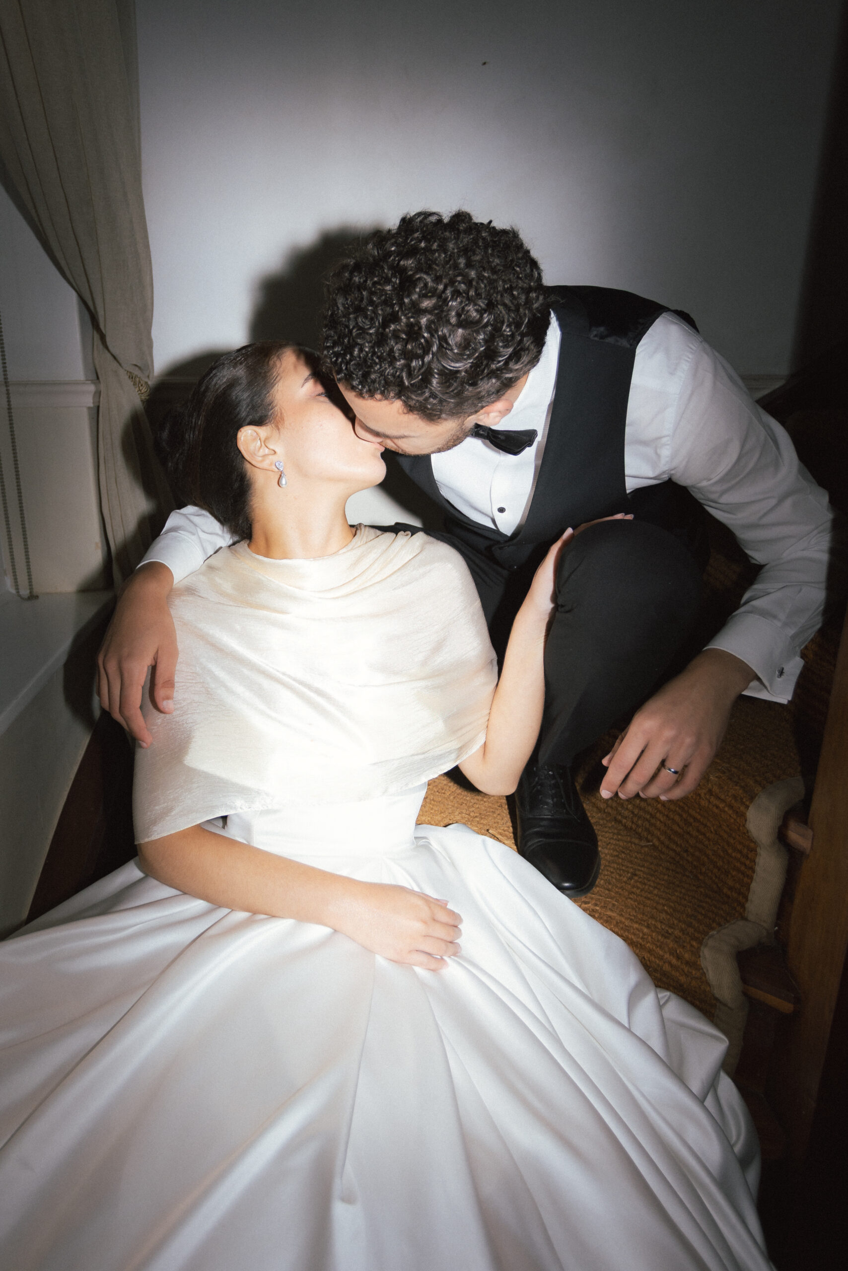 Direct flash photo of a wedding couple kissing, used as an icon for wedding photography packages.