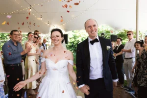 Wedding couple walking through rose petal confetti.