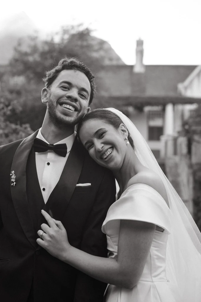 Black and white Wedding photograph of a couple in with an old building behind them