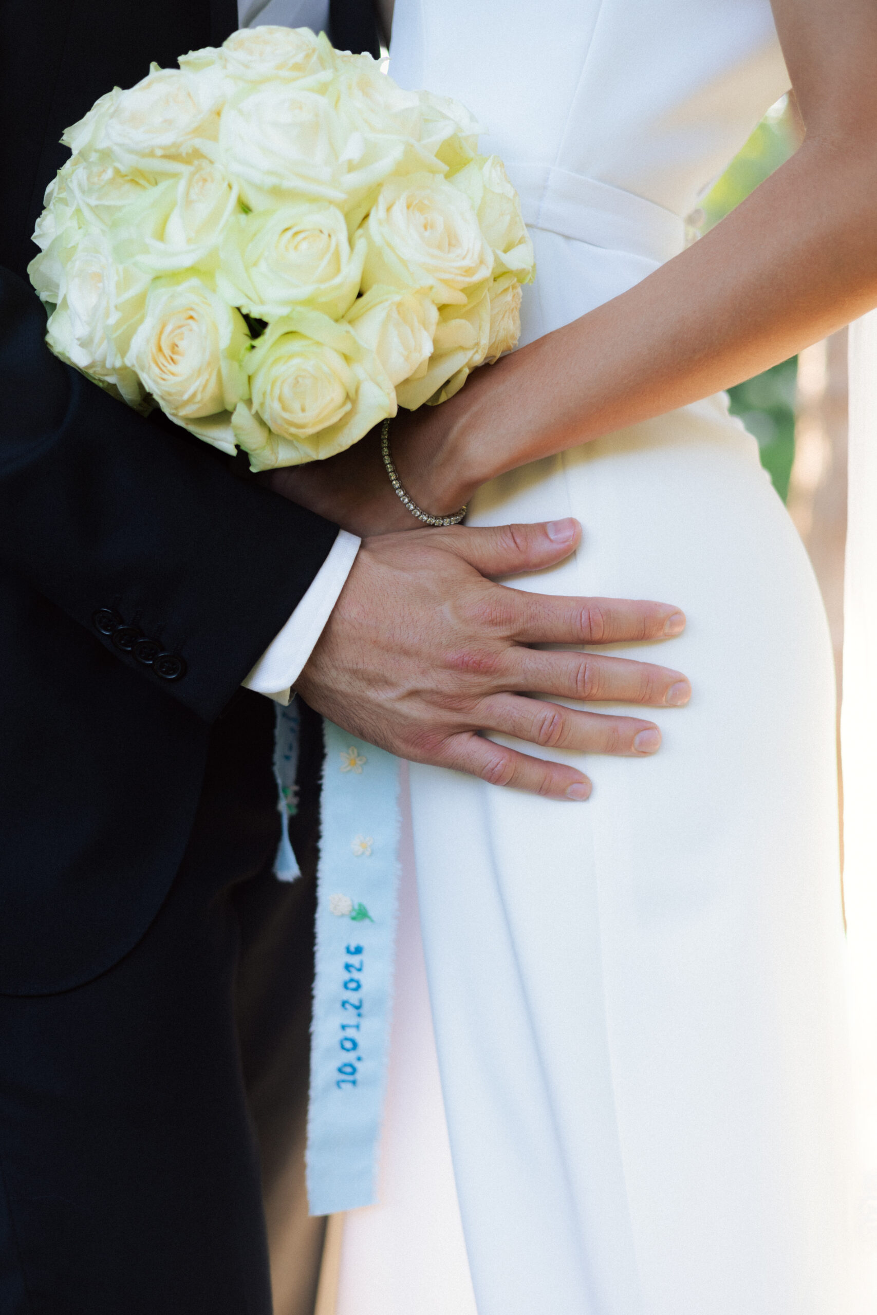 Wedding couple's close up on hands and flowers