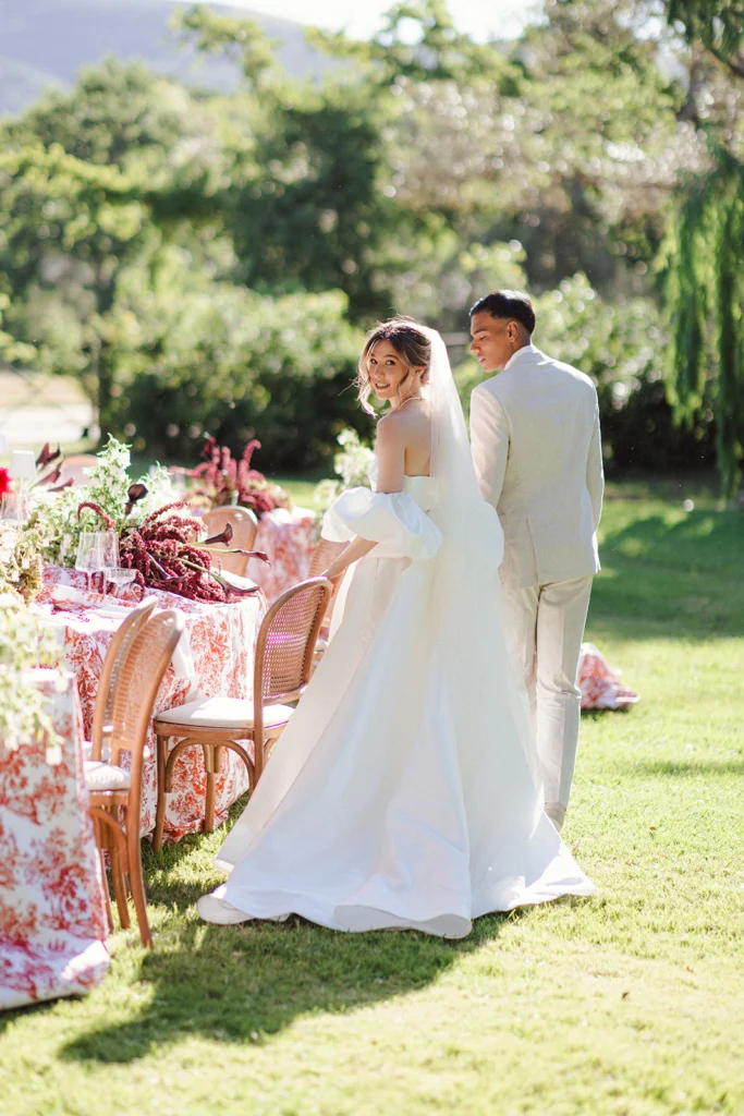 Bride and groom walking around their tables cape.